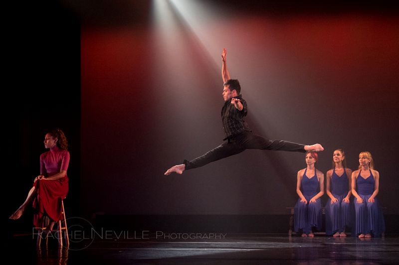 male dancer jumping over seated women jete stage live performance photo by rachel neville