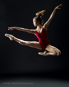 muscular dancer powerful jump red leotard ponytail